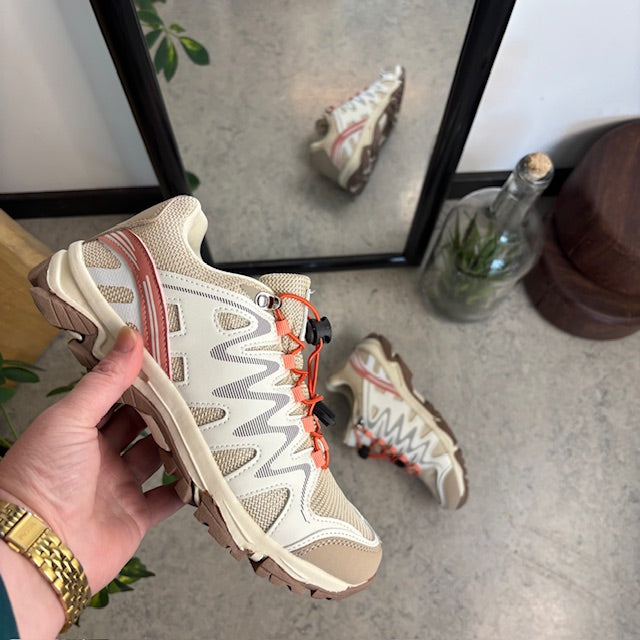 Fleksible beige sneakers med elastiksnørebånd.