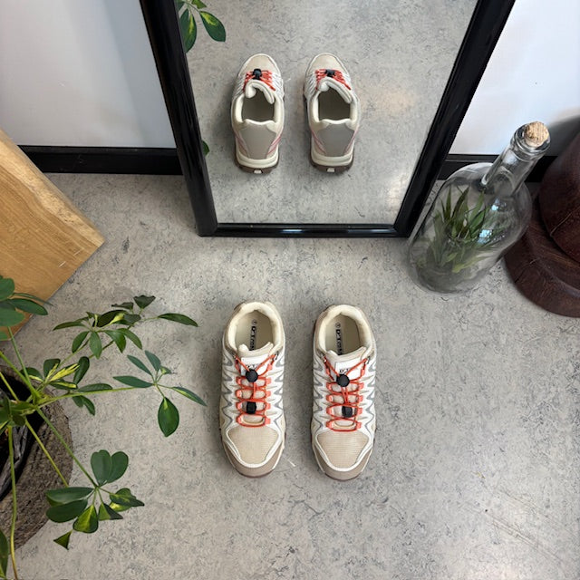 Fleksible beige sneakers med elastiksnørebånd.