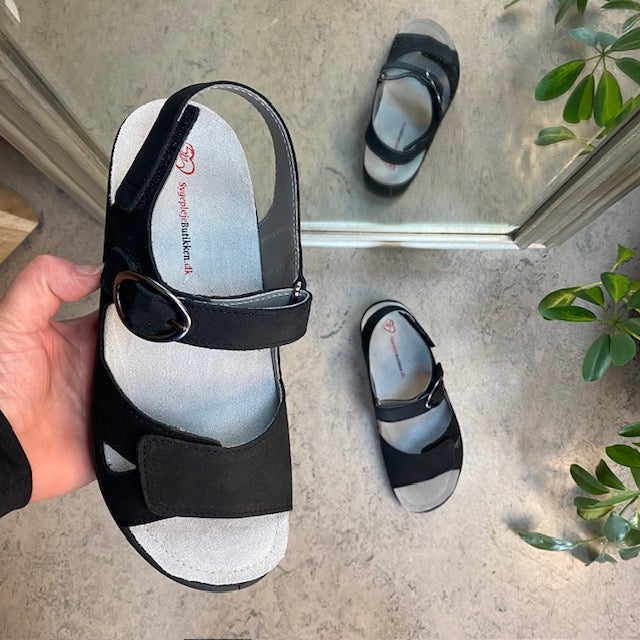 Sort lædersandal med tre justerbare remme og en aftagelig indersål.