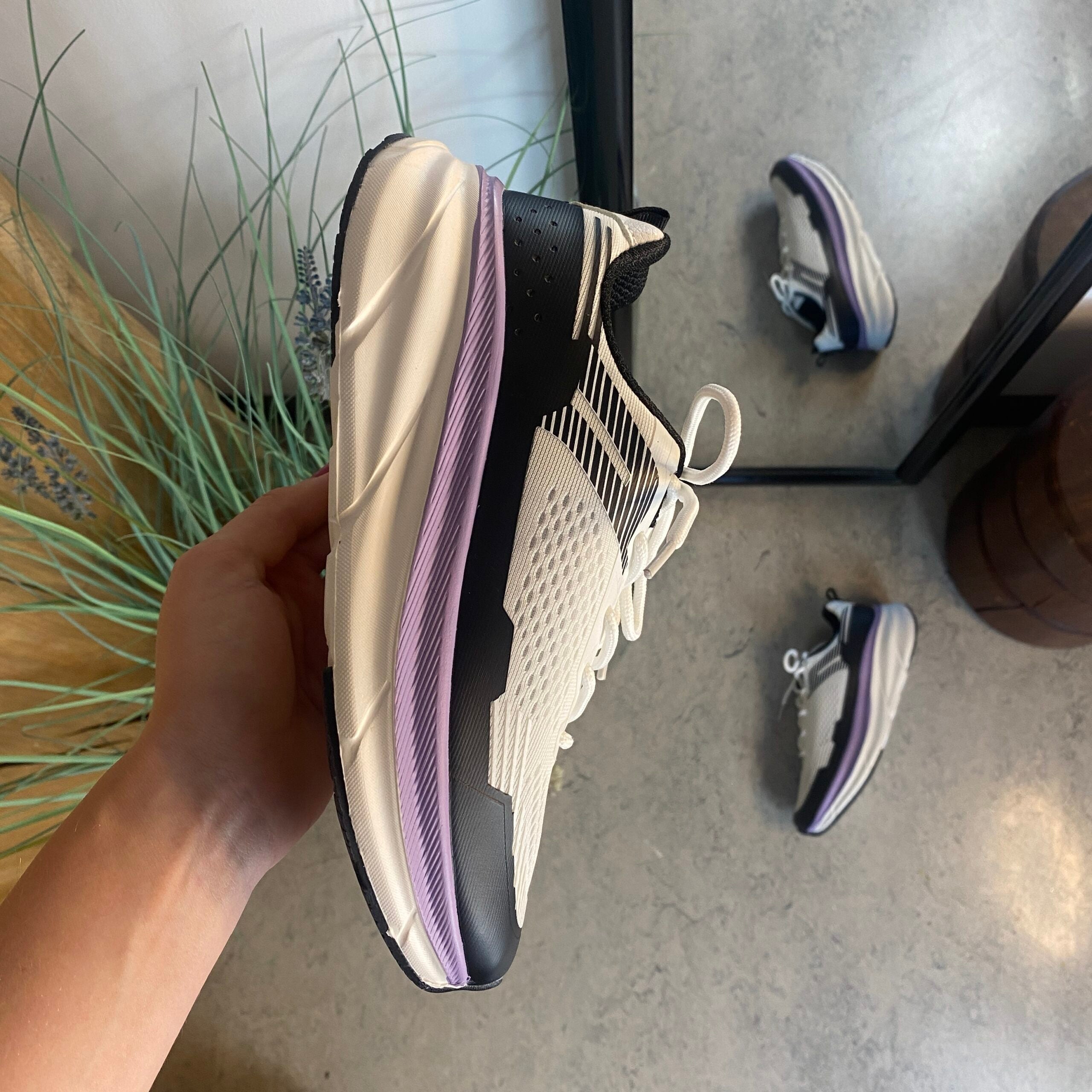 Hvide, stødabsorberende sko i åndbart mesh.