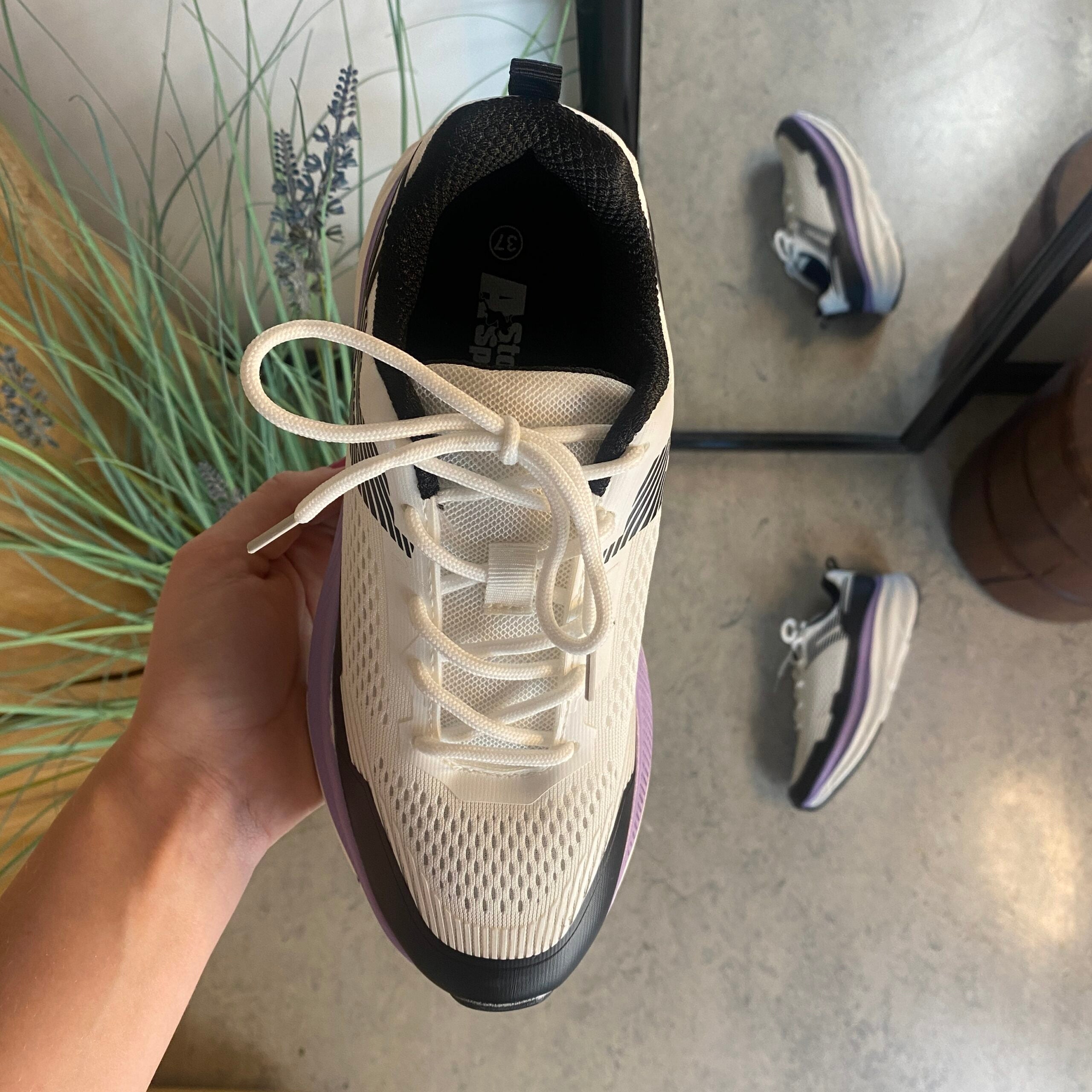 Hvide, stødabsorberende sko i åndbart mesh.