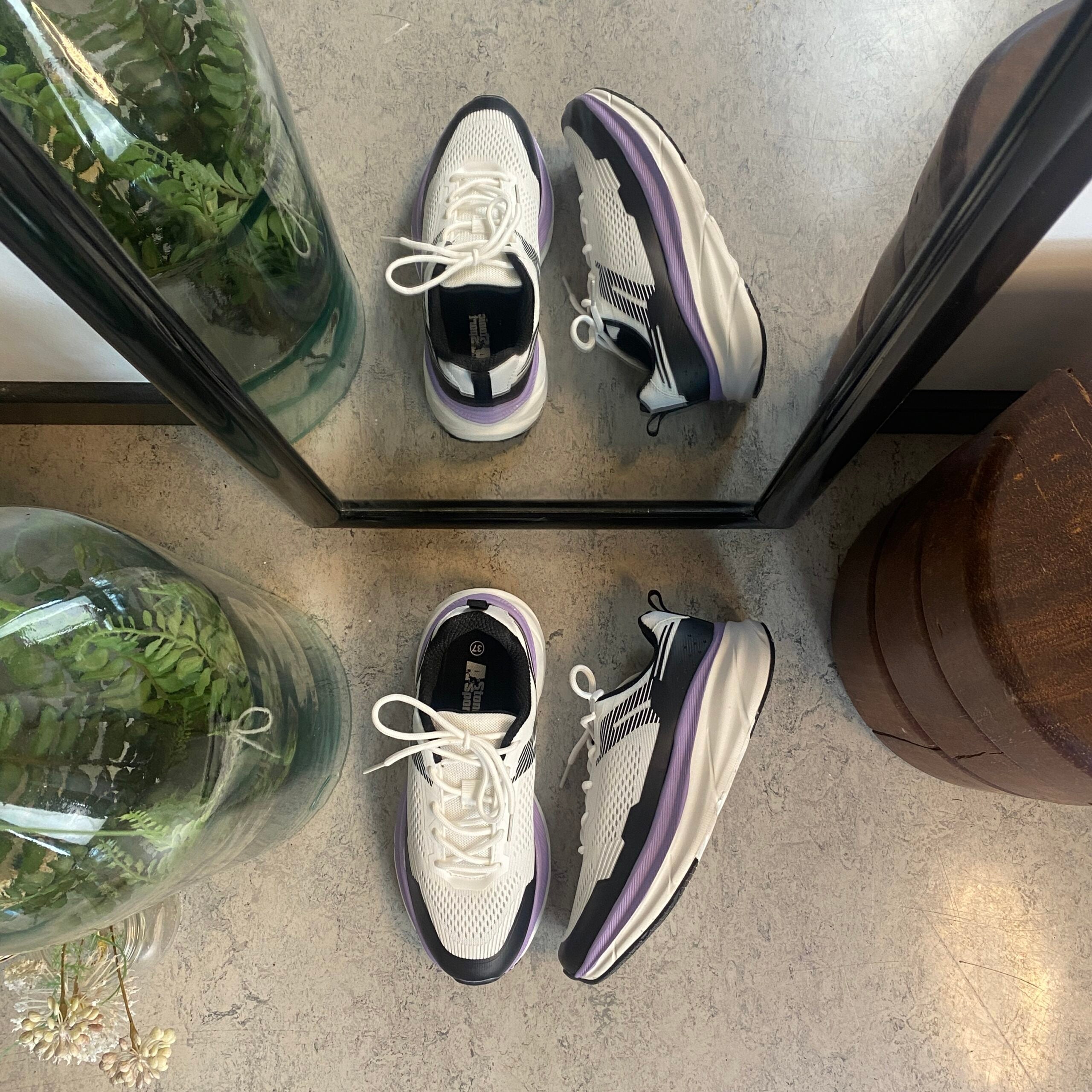 Hvide, stødabsorberende sko i åndbart mesh.