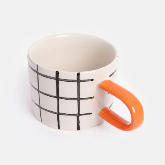 Moderne krus med ternet mønster og orange hank – stilfuldt design til kaffe & te